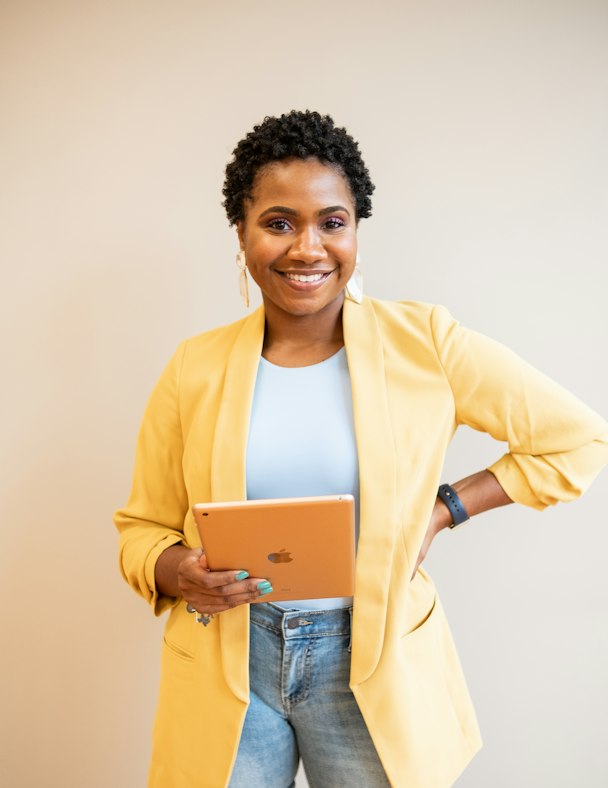 Portrait d'Awa Koné, directrice générale, souriante en blazer jaune