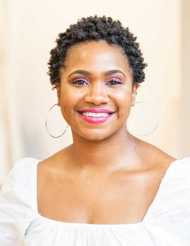 Portrait de Mariam Traoré, directrice de clientèle, au sourire éclatant et aux cheveux courts